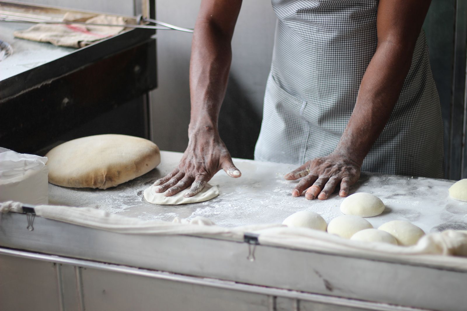 Boulanger façonnant ses pâtons sur le plan de travail fariné