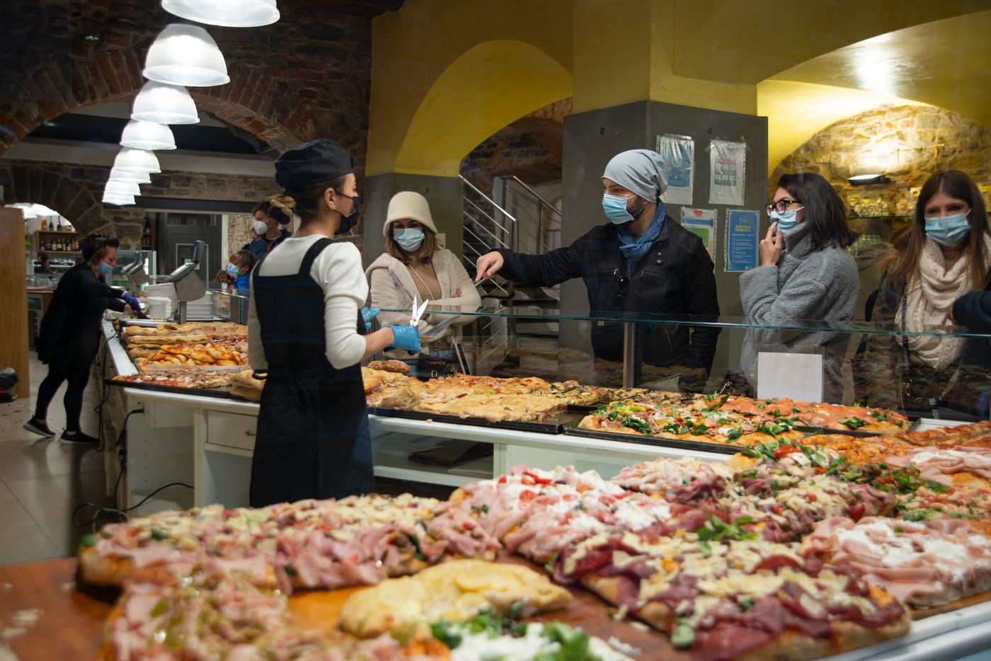 Clients alignés devant le comptoir d'une boulangerie à l'heure de pointe