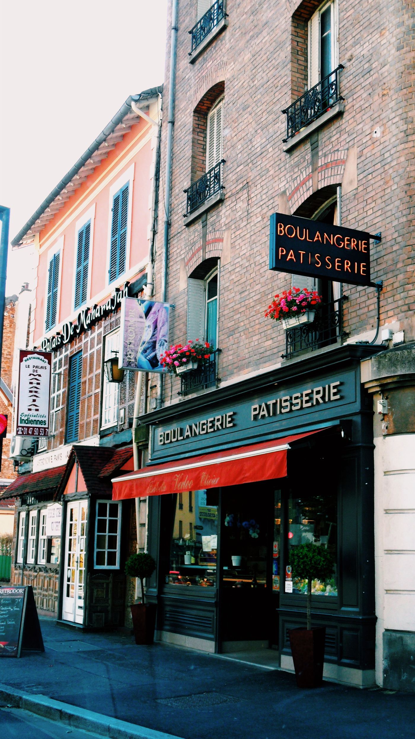 Façade d'une boulangerie-pâtisserie de rue, store rouge déployé